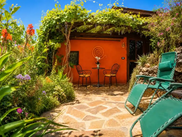 Sonnige Veranda mit Liegestühlen und Garten für Erholung während des Fastenurlaubs auf La Palma.