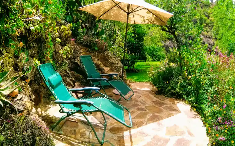 Gemütliche Liegestühle auf der blumengeschmückten Terrasse unserer Eco Yoga Retreat Oase auf La Palma.
